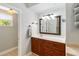 Bright bathroom vanity with wooden cabinetry, white countertops, and a decorative framed mirror at 2250 Davis Dr, New Smyrna Beach, FL 32168