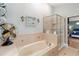 Modern bathroom with a soaking tub, glass-enclosed shower, and tile surround at 2250 Davis Dr, New Smyrna Beach, FL 32168