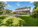 A shot of the back of the home showcases the balcony overlooking a pool and lush green lawn at 2250 Davis Dr, New Smyrna Beach, FL 32168
