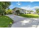 Two-story home features a long driveway leading to an attached garage, complemented by a spacious front yard at 2250 Davis Dr, New Smyrna Beach, FL 32168