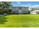Inviting two-story home featuring a large front yard with lush, green grass and manicured landscaping at 2250 Davis Dr, New Smyrna Beach, FL 32168
