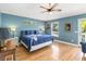 Serene main bedroom with a ceiling fan, hardwood floors, and a private door to a balcony at 2250 Davis Dr, New Smyrna Beach, FL 32168
