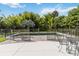 Private backyard pool area enclosed with a safety fence and patio furniture, surrounded by lush greenery at 2250 Davis Dr, New Smyrna Beach, FL 32168