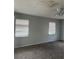Empty room with two windows, gray walls, and beige carpet at 2366 Florida Dr, Deltona, FL 32738