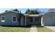 The front exterior of this house shows a gray house with a tree in front and a walkway at 2366 Florida Dr, Deltona, FL 32738