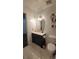 Bathroom featuring a vanity with modern fixtures, lighted mirror, toilet and stylish marble tile flooring at 2380 Spring Hollow Drive, Orange City, FL 32763