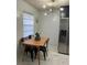 A modern dining area features a wooden table with black chairs, stylish lighting, and stainless steel refrigerator at 2380 Spring Hollow Drive, Orange City, FL 32763