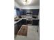 Beautiful kitchen features navy cabinets, marble-look floors and stainless steel appliances, blending style and functionality at 2380 Spring Hollow Drive, Orange City, FL 32763