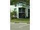 A two-story condo with screened balconies and lush green lawn and landscaping at 2565 Oak Park Way # 213, Orlando, FL 32822