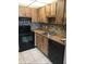 Charming kitchen with wood cabinets, mosaic backsplash, and modern black appliances at 2565 Oak Park Way # 213, Orlando, FL 32822