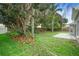 Spacious backyard with mature trees, a concrete patio, and a wooden fence at 2708 Smithfield Dr, Orlando, FL 32837