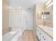 Bright bathroom featuring tiled floors, a tub and glass-blocked shower, and double vanity sinks at 2708 Smithfield Dr, Orlando, FL 32837