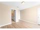 Bedroom with neutral walls and wood-look floors with an open bathroom entrance at 2708 Smithfield Dr, Orlando, FL 32837