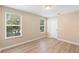 Bright bedroom featuring wood-look floors, neutral walls, and two windows offering ample natural light at 2708 Smithfield Dr, Orlando, FL 32837