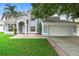 Attractive two-story home with a manicured lawn, complemented by mature trees, and a two-car garage at 2708 Smithfield Dr, Orlando, FL 32837