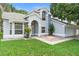 Charming gray home with manicured lawn, arched entryway, and lovely trees in a great neighborhood at 2708 Smithfield Dr, Orlando, FL 32837