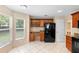 Well-lit kitchen with wooden cabinets, black appliances, and tile flooring at 2708 Smithfield Dr, Orlando, FL 32837