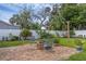 Serene backyard patio featuring a charming fire pit surrounded by lush greenery at 2720 Kumquat Dr, Edgewater, FL 32141