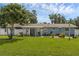 Expansive backyard showcasing a charming blue home with a covered patio at 2720 Kumquat Dr, Edgewater, FL 32141