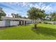 Lush backyard featuring a well-manicured lawn and mature shade trees at 2720 Kumquat Dr, Edgewater, FL 32141