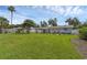 Spacious backyard with green lawn, blue house and a covered patio at 2720 Kumquat Dr, Edgewater, FL 32141