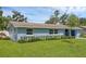 A light blue single-story house features tidy landscaping and a lush green lawn at 2720 Kumquat Dr, Edgewater, FL 32141