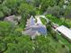 A home with solar panels is showcased from above, nestled among verdant trees and lush landscaping at 2770 Red Wing Vlg, Deland, FL 32720