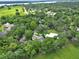 Lush, green aerial view of a secluded home among mature trees, pasture, and winding driveway near a large lake at 2770 Red Wing Vlg, Deland, FL 32720