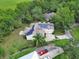 A sprawling residence with solar panels is captured from above, enveloped by lush greenery and mature trees at 2770 Red Wing Vlg, Deland, FL 32720
