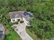 An aerial view of a beautiful residence with solar panels, surrounded by lush trees and an American flag at 2770 Red Wing Vlg, Deland, FL 32720