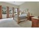 Cozy bedroom with unique wooden bedframe, three large windows, and soft neutral tones for a relaxing ambiance at 2770 Red Wing Vlg, Deland, FL 32720