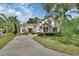Stunning two-story home featuring stone accents, a red front door, and lush landscaping at 2770 Red Wing Vlg, Deland, FL 32720