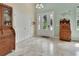 Inviting foyer with travertine floors, a decorative glass front door, and wooden furniture accents at 2770 Red Wing Vlg, Deland, FL 32720