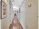Long hallway with hardwood floors and multiple closet doors, offering ample storage at 2770 Red Wing Vlg, Deland, FL 32720