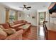 Cozy living room with a sectional sofa, ceiling fan, wood floors, and natural light from the windows at 2770 Red Wing Vlg, Deland, FL 32720