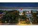 Wide aerial shot highlights a home near the beach with a pool and lush surrounding landscape, indicated by arrow at 2833 S Atlantic Ave, Daytona Beach, FL 32118