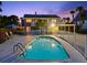 Backyard pool view at dusk featuring a fenced yard, covered parking, and exterior staircase at 2833 S Atlantic Ave, Daytona Beach, FL 32118