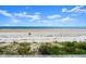 Panoramic beach view showcasing blue ocean waters, sandy shores, and lush vegetation from the wooden deck at 2833 S Atlantic Ave, Daytona Beach, FL 32118