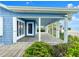 Blue beach house with a large tiled patio overlooking lush greenery and partial ocean views at 2833 S Atlantic Ave, Daytona Beach, FL 32118