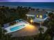 Aerial dusk view of an estate featuring a backyard pool, covered parking, and beach access at 2833 S Atlantic Ave, Daytona Beach, FL 32118