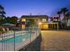 Exterior twilight view of a home featuring a backyard pool, covered parking, and fenced yard at 2833 S Atlantic Ave, Daytona Beach, FL 32118