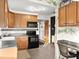 Kitchen with wood cabinets, black appliances, and adjacent desk area at 2833 S Atlantic Ave, Daytona Beach, FL 32118