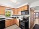 Well-lit kitchen featuring wood cabinets, black appliances, and tile flooring at 2833 S Atlantic Ave, Daytona Beach, FL 32118