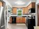 Efficient kitchen with stainless steel appliances, wood cabinets, and a bright window over the sink at 2833 S Atlantic Ave, Daytona Beach, FL 32118