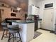 Functional kitchen featuring white cabinets, a breakfast bar with seating, and easy access to the living area at 2875 Delrose N Dr, Lakeland, FL 33805