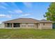 A single story house has a big backyard with a tan brick, screened in patio, and lawn at 2880 Boyd Ct, Deltona, FL 32738