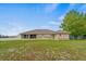 This single story house features a big backyard with a tan brick exterior and an ample lawn at 2880 Boyd Ct, Deltona, FL 32738