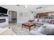 Open living room featuring neutral colors, a cozy fireplace, and seamless flow to the kitchen area at 307 Ravenshill Way, Deland, FL 32724