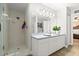 Bright bathroom featuring a stand-up shower with glass door, white vanity, and neutral tile throughout at 3132 Mango Tree Dr, Edgewater, FL 32141