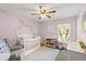 Cozy Bedroom featuring a crib, comfortable armchair, and soft lighting creating a soothing atmosphere at 3132 Mango Tree Dr, Edgewater, FL 32141